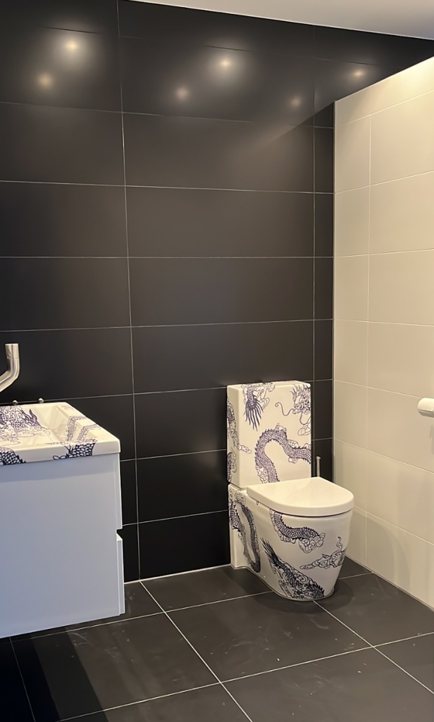 Badkamer met toilet en wastafel met dragon design van TATTOOtoilet- Esther Derkx