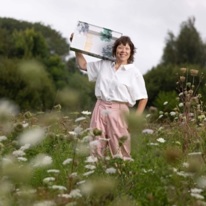 EstherDerkx-TATTOOtoilet-2025- Portretfoto van Esther Derkx met een wastafel haar schouder. De wastafel is voorzien van design 'Bossages' gemaakt door TATTOOtoilet, Esther Derkx
