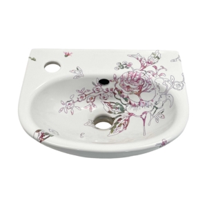 Toiletfontein met een illustratie van een roos, bestaande uit fijne, zwarte lijnen en roze bloem fragmenten die over de randen van het fonteintje heen lopen.